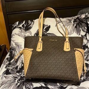 Michael Kors Voyager. New with tags. It’s just sitting in the closet.